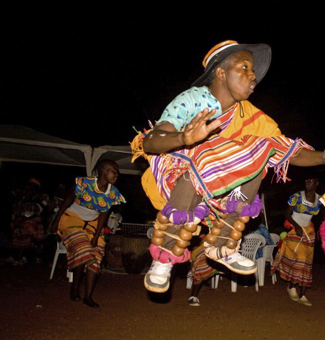 Traditional Bakisimba dance performance in Uganda, showcasing vibrant costumes, energetic movements, and rhythmic drumming.
