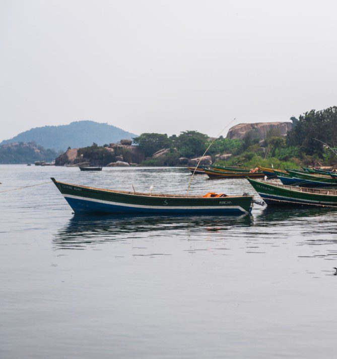 Lake Victoria at sunrise with calm waters and scenic backdrop.