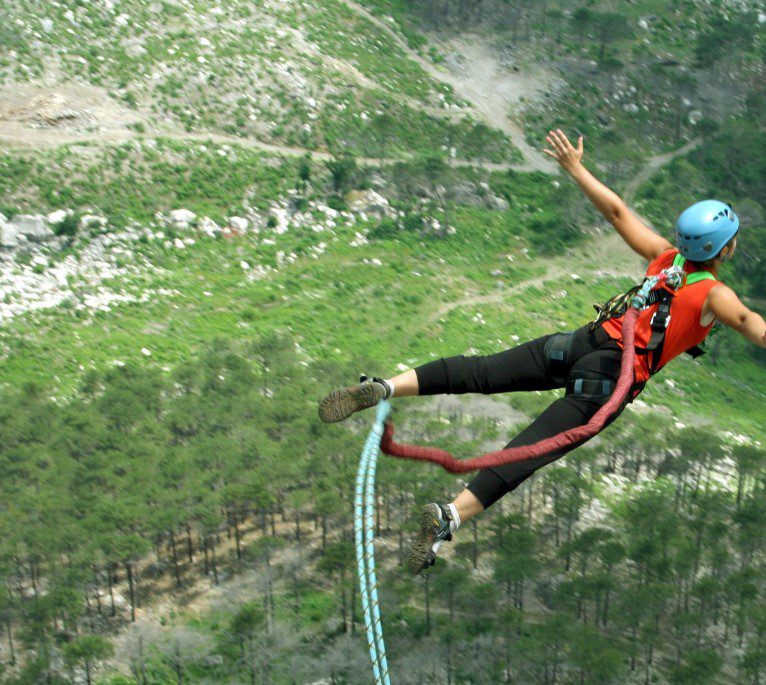 Bungee jumper leaping off a bridge with breathtaking views in Africa.